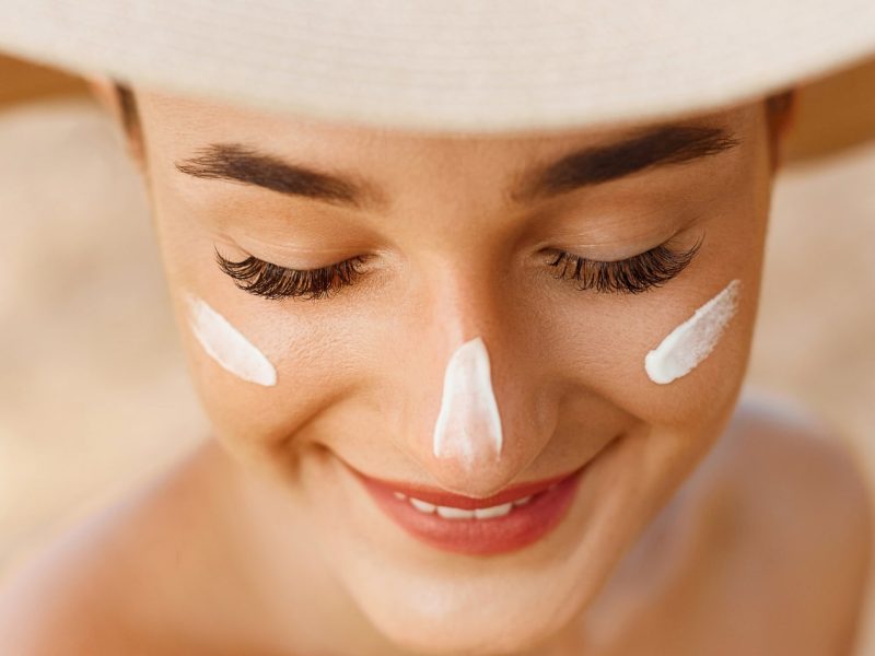 spf face cream on womans cheeks and nose