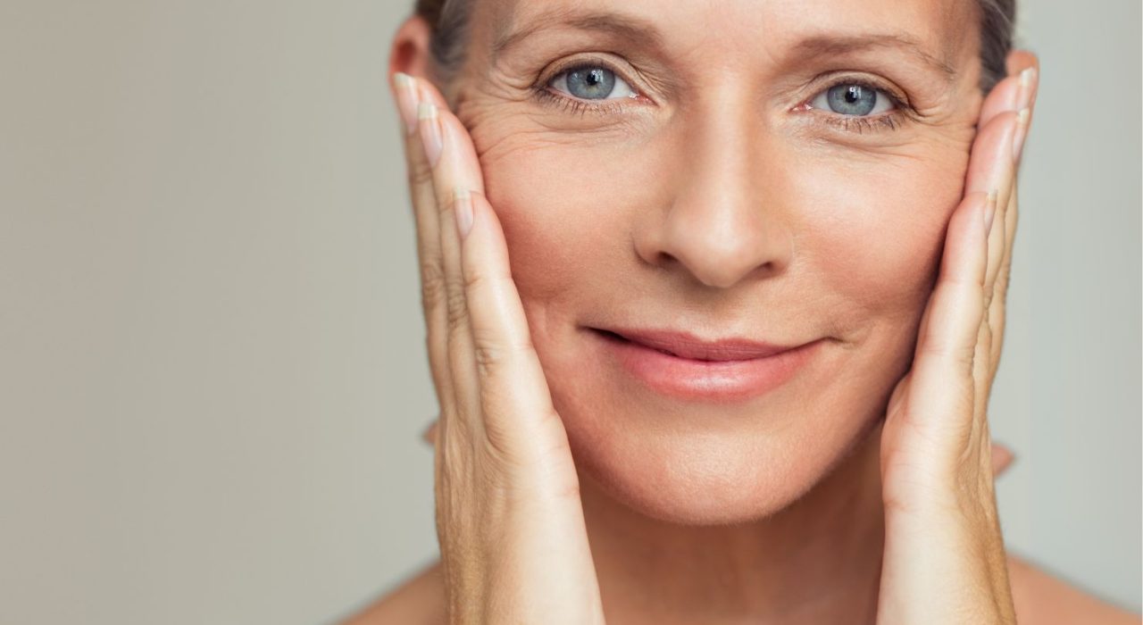 mature lady women with clear skin hands touching face menopause